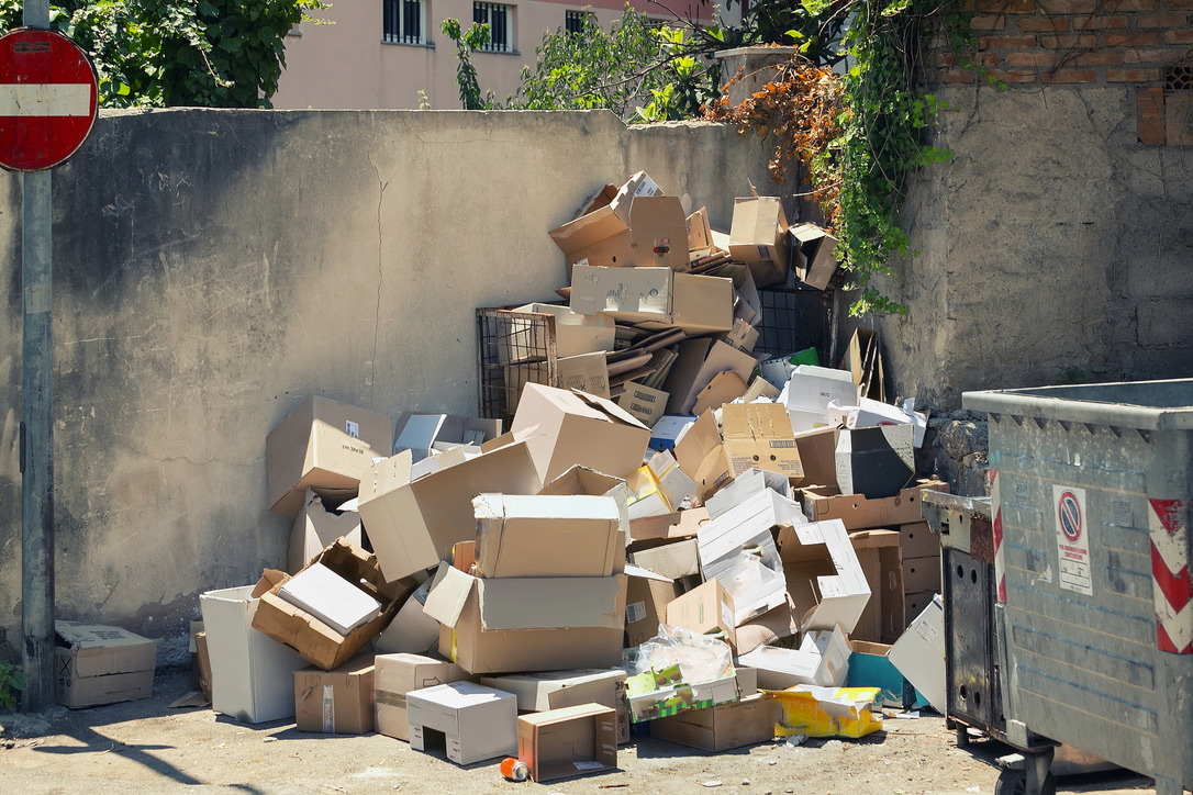 Garbage dumpsters cardboard boxes full of trash